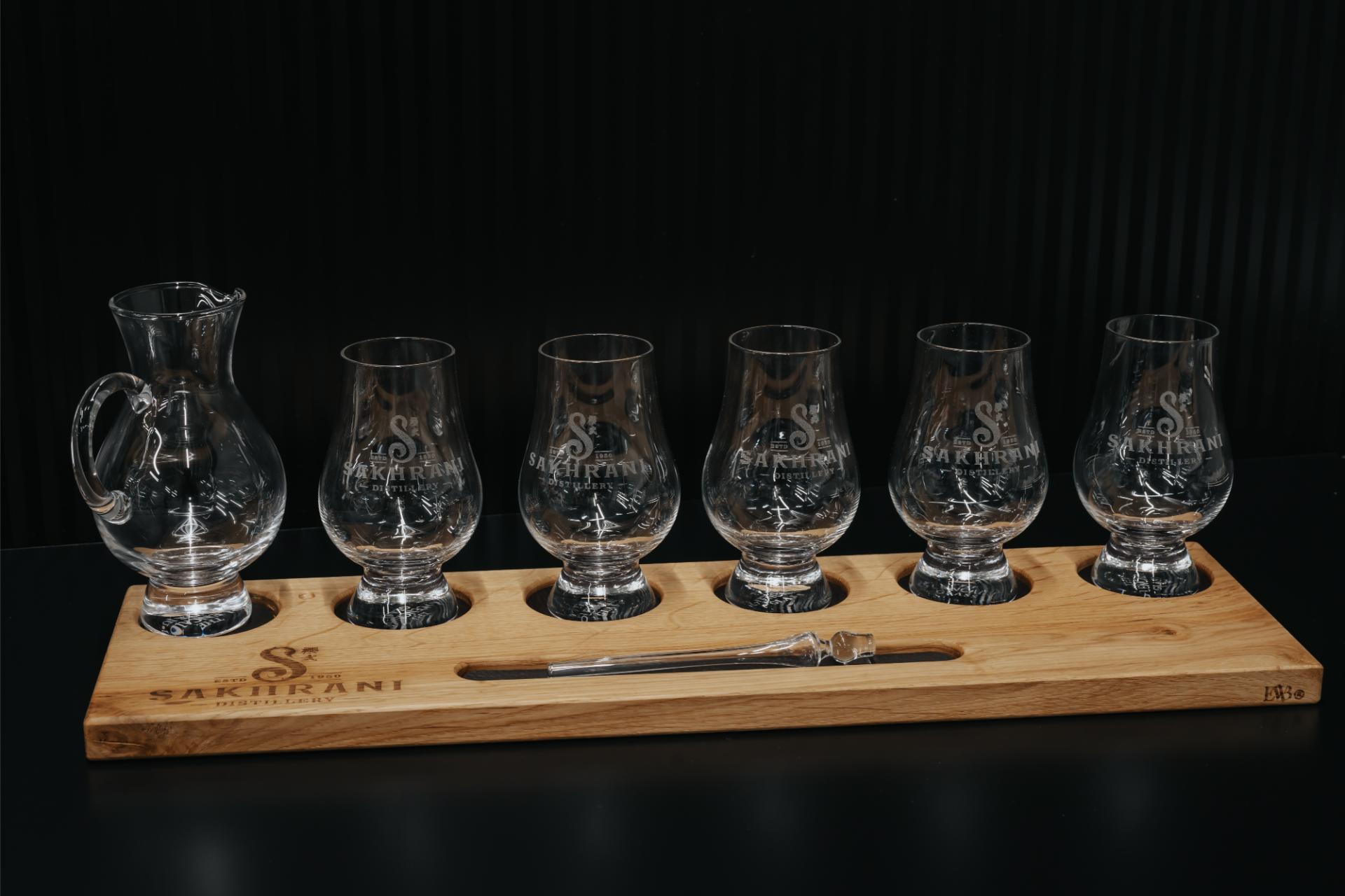 Reeks gegraveerde glazen in houten houder als voorbeeld van lasergravure op maat.